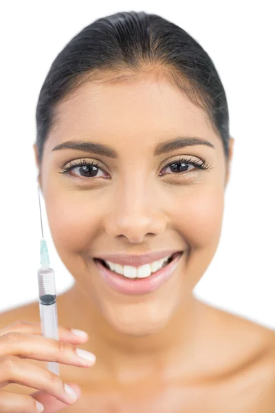 Smiling nude brunette holding injection — Stock Photo, Image