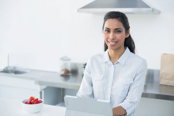 Vrolijke vrouw die werkt op haar Tablet PC glimlachen op camera — Stockfoto