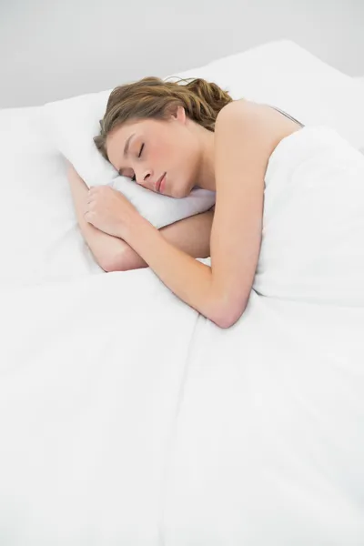 Schöne schlafende Frau liegt unter der Decke auf ihrem weißen Bett — Stockfoto