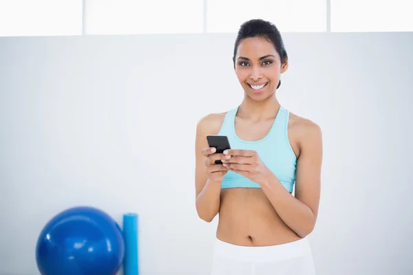 Atractiva mujer tranquila mensajes de texto con su teléfono inteligente — Foto de Stock