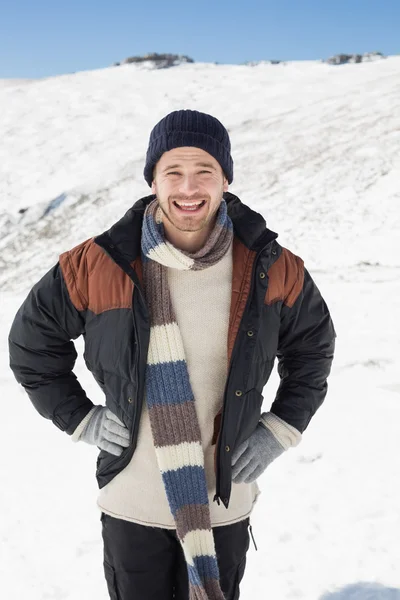 Uomo in abiti caldi in piedi su un paesaggio innevato — Foto Stock