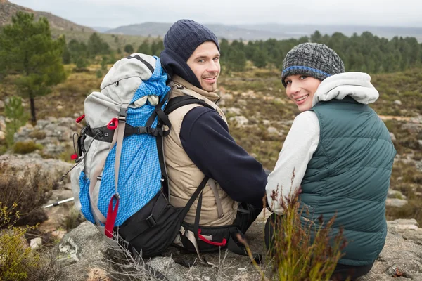 Porträtt av ett par med ryggsäck avkopplande samtidigt på en vandring — Stockfoto