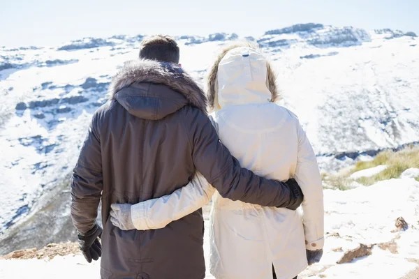 Paar in Jacken blickt auf verschneites Gebirge — Stockfoto