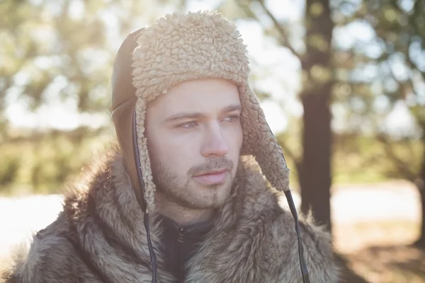 Yakın çekim sıcak giysiler, uzak ormanın içinde bakarak adam — Stok fotoğraf
