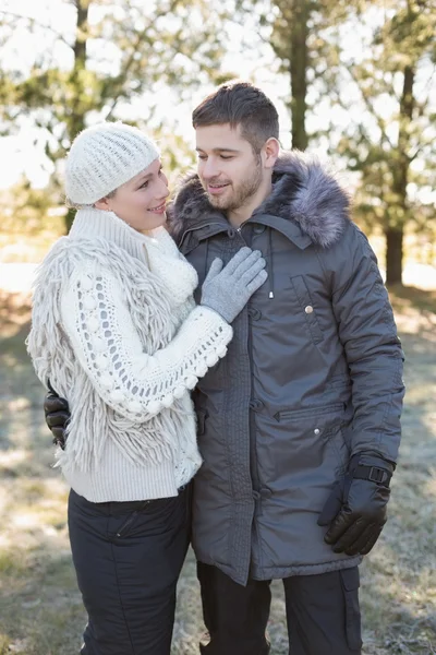 Pareja cariñosa en ropa de invierno en el bosque — Foto de Stock