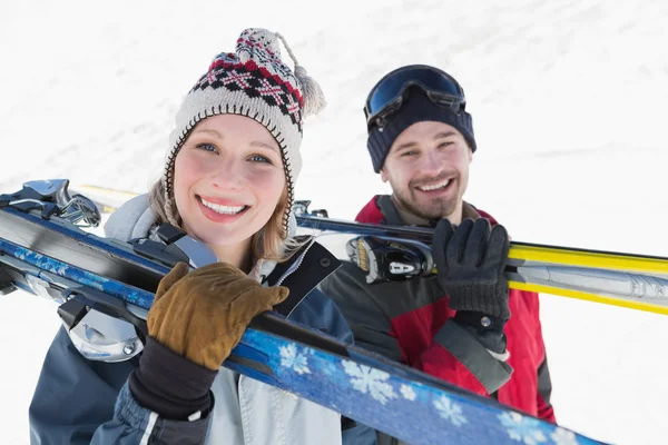 Close-up of a smiling couple with ski boards on snow — Stock Photo, Image