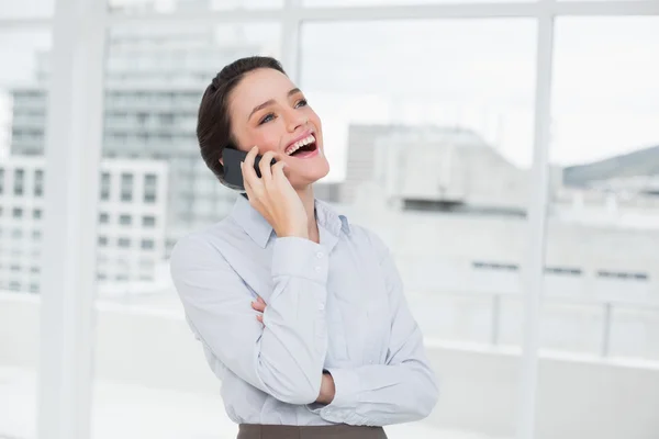 Glada affärskvinna med hjälp av mobiltelefon i office — Stockfoto