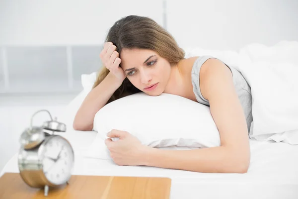 Calm attractive woman lying thoughtful on her bed — Stock Photo, Image