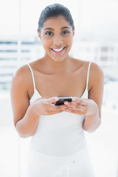 Cheerful toned brunette holding mobile phone — Stock Photo, Image