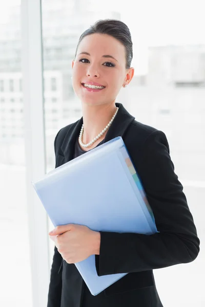 Elegante mujer de negocios de pie contra la pared de vidrio de oficina — Foto de Stock