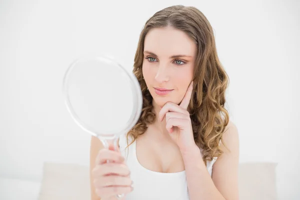 Mladá žena při pohledu do zrcadla — Stock fotografie