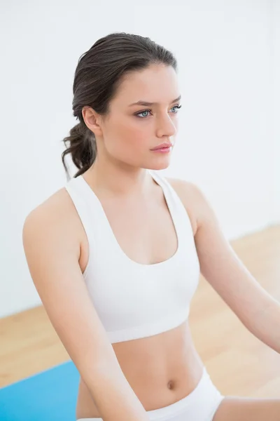 Stonowanych brunetka siedzi w studiu fitness — Zdjęcie stockowe