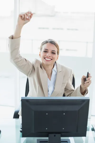 Content blonde businesswoman cheering sitting on her swivel chair looking at camera — Stock Photo, Image