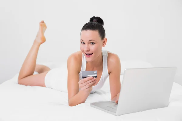 Casual kadın yatakta online alışveriş yaparken — Stok fotoğraf