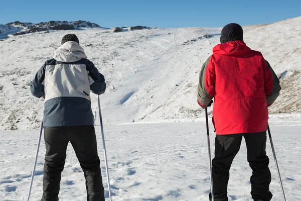 Vue arrière d'un couple avec bâtons de ski sur neige — Photo