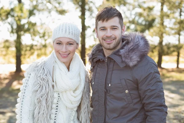 Lachende paar in winter kleding in het bos — Stockfoto