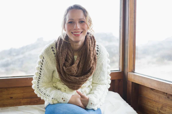 Cute woman sitting in warm clothing in cabin — Stock Photo, Image