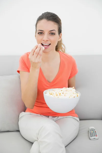 Jovem divertida assistindo televisão comendo pipocas — Fotografia de Stock