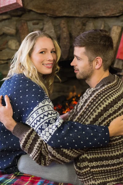 Romantic couple smiling in front of fireplace — Stock Photo, Image