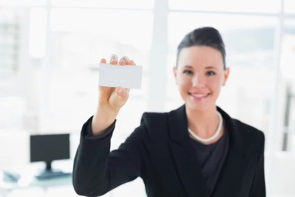 Элегантная деловая женщина, держащая визитку в офисе — стоковое фото