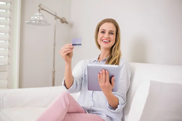 Ridere bionda casual utilizzando tablet per lo shopping online — Foto Stock