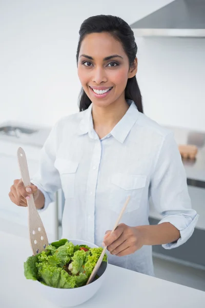 Attraente donna dai capelli neri che prepara l'insalata in cucina — Foto Stock