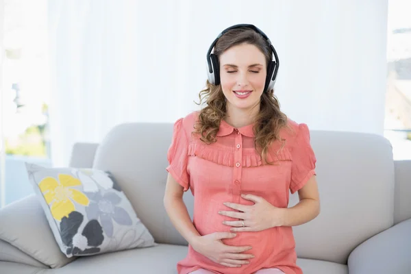 Peaceful pregnant woman relaxing listening to music — Stock Photo, Image
