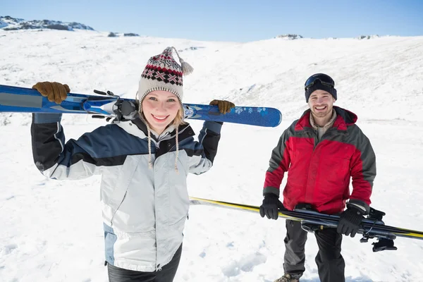 Retrato de um casal sorridente com pranchas de esqui na neve — Fotografia de Stock