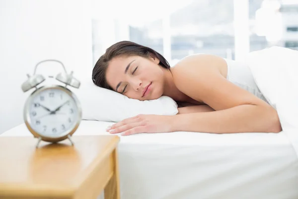 Спящая женщина с размытым будильником на переднем плане — стоковое фото