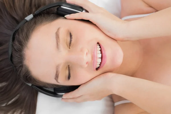 Žena líbí hudba v posteli — Stock fotografie