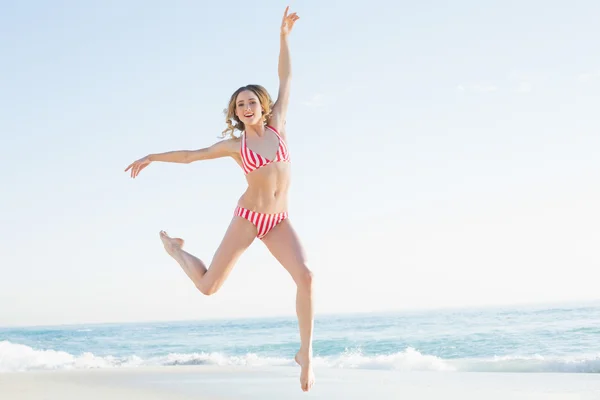 Lovely young woman jumping on the beach — Stock Photo, Image