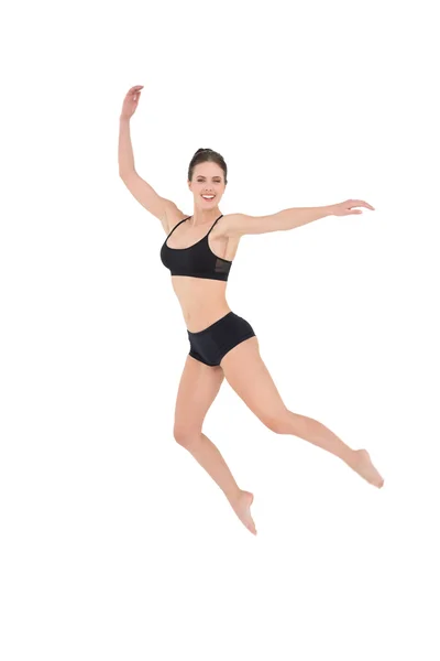 Sportliche Frau springt isoliert auf weißem Hintergrund — Stockfoto