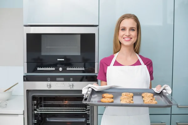 Casual attractive woman holding baking tray with cookies — Stock Photo, Image