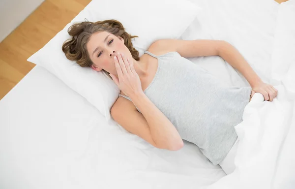 Superbe femme fatiguée couchée sous la couverture sur son lit — Photo