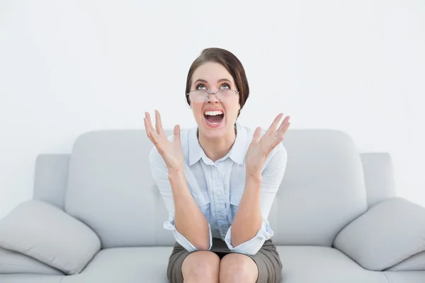 Descontente mulher bem vestida gritando no sofá — Fotografia de Stock