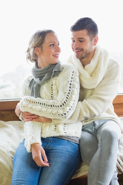 Pareja en ropa de invierno sentado contra la ventana —  Fotos de Stock