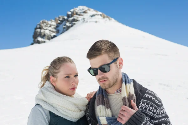 Paar in warmer Kleidung vor verschneitem Hügel — Stockfoto