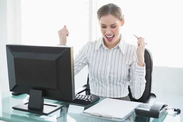 Ευτυχής κομψό επιχειρηματίας που κάθεται στο γραφείο της μπροστά από τον υπολογιστή — Φωτογραφία Αρχείου