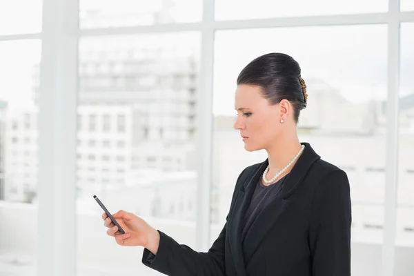Elegante mujer de negocios mirando el teléfono celular — Foto de Stock