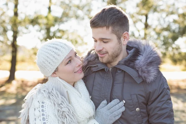 Coppia sorridente in abbigliamento invernale nel bosco — Foto Stock