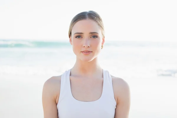 Mooie jonge vrouw zitten op het strand — Stockfoto