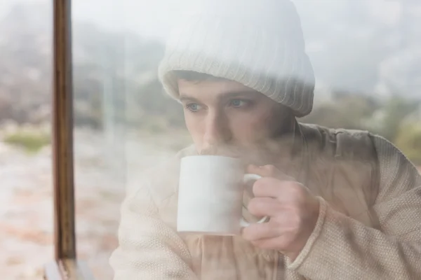 Man drinking coffee seen through cabin window — Stock Photo, Image