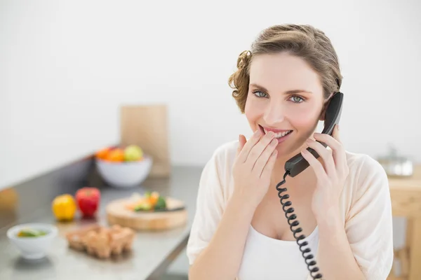 Güzel kadın bir telefon için telefon edip onu mutfakta oturup eğlenerek — Stok fotoğraf