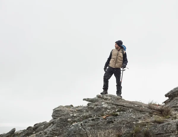 L'uomo in piedi sulla roccia contro il cielo limpido — Foto Stock