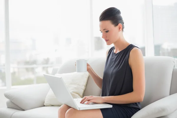 Bella donna ben vestita che utilizza il computer portatile mentre prende il caffè — Foto Stock