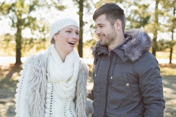 Pareja alegre en ropa de invierno en el bosque — Foto de Stock