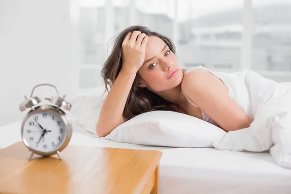 Portret van een mooie jonge vrouw in bed liggen — Stockfoto