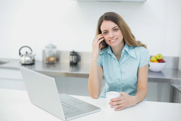 Attraente giovane donna in posa nella sua cucina sorridente alla fotocamera — Foto Stock