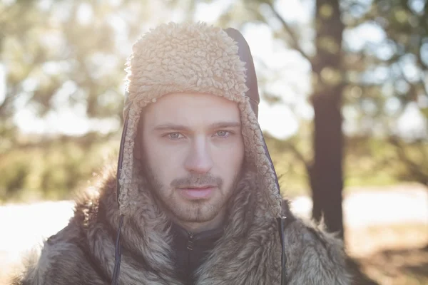 Nahaufnahme eines gutaussehenden Mannes in warmer Kleidung im Wald — Stockfoto