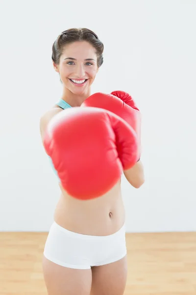 Hermosa mujer en guantes de boxeo rojos en el gimnasio —  Fotos de Stock